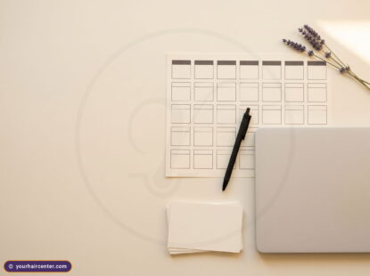 Overhead desk flat-lay for choosing the best country for hair transplant, with a blank comparison grid, pen, and laptop
